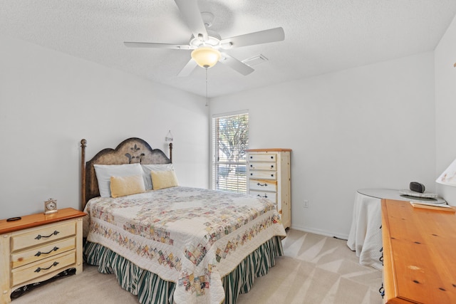 carpeted bedroom with ceiling fan and a textured ceiling