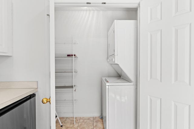 clothes washing area featuring stacked washing maching and dryer and light tile patterned floors