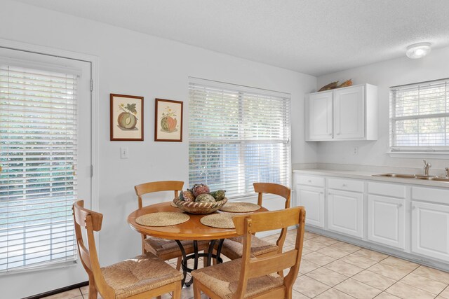 tiled dining space with a textured ceiling and sink