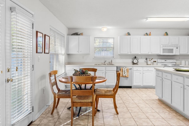 kitchen with white cabinetry, white appliances, sink, and light tile patterned floors