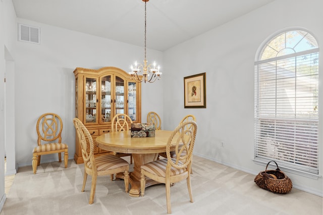 carpeted dining room with an inviting chandelier