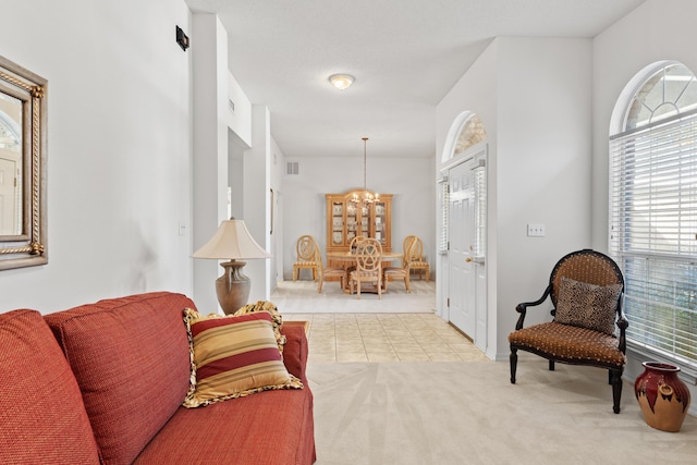 living area with light colored carpet and a notable chandelier