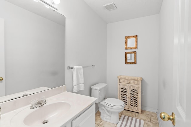 bathroom featuring tile patterned floors, vanity, toilet, and a textured ceiling