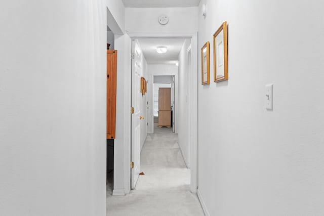 hall with light colored carpet