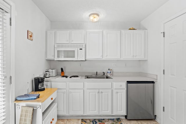 kitchen with white cabinetry, sink, a textured ceiling, white appliances, and light tile patterned floors