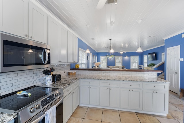 kitchen with kitchen peninsula, white cabinets, stainless steel appliances, and pendant lighting