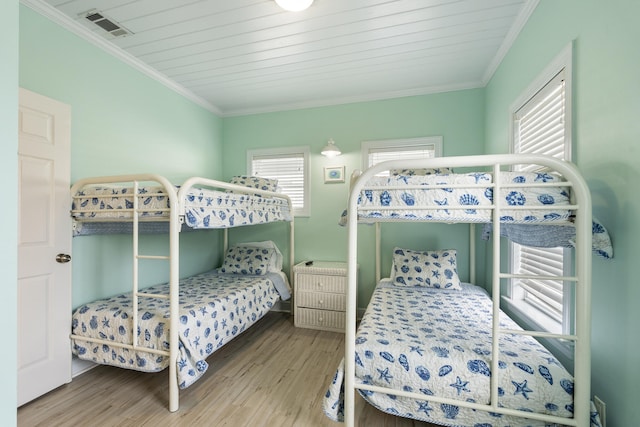 bedroom with hardwood / wood-style floors, wood ceiling, and ornamental molding