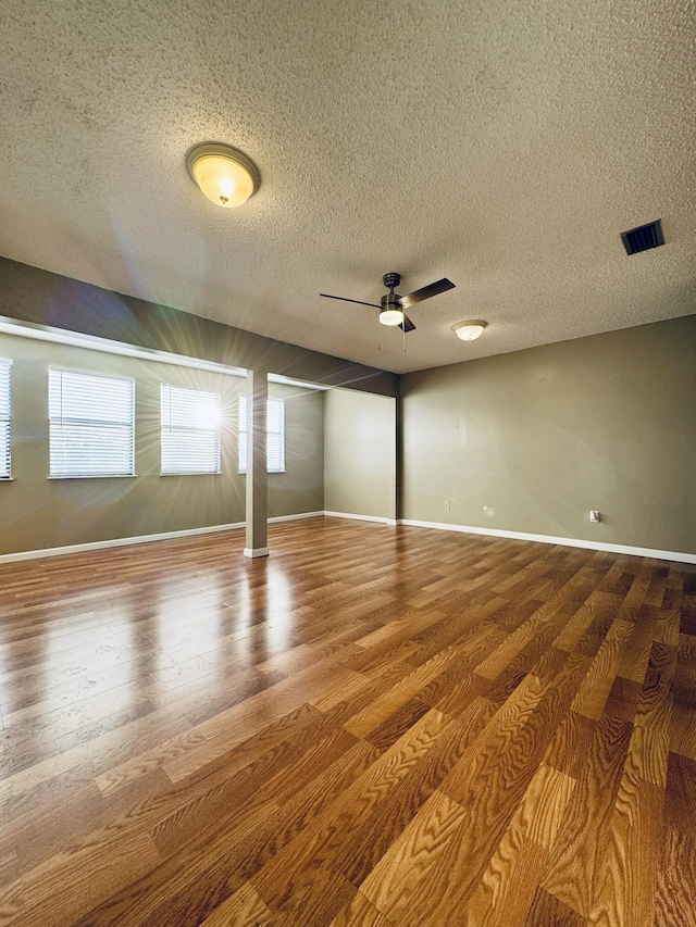 unfurnished room featuring a textured ceiling, hardwood / wood-style flooring, and ceiling fan