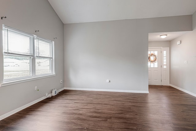 spare room featuring dark wood-type flooring and plenty of natural light