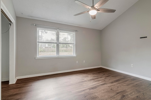 unfurnished bedroom with ceiling fan, a textured ceiling, dark hardwood / wood-style flooring, a closet, and vaulted ceiling