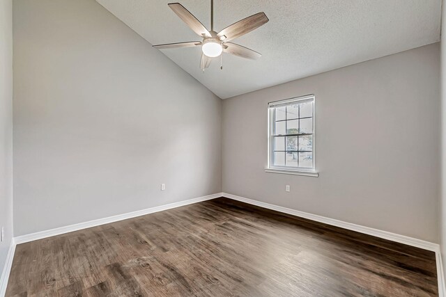 unfurnished room featuring dark wood-style flooring, ceiling fan, vaulted ceiling, and baseboards