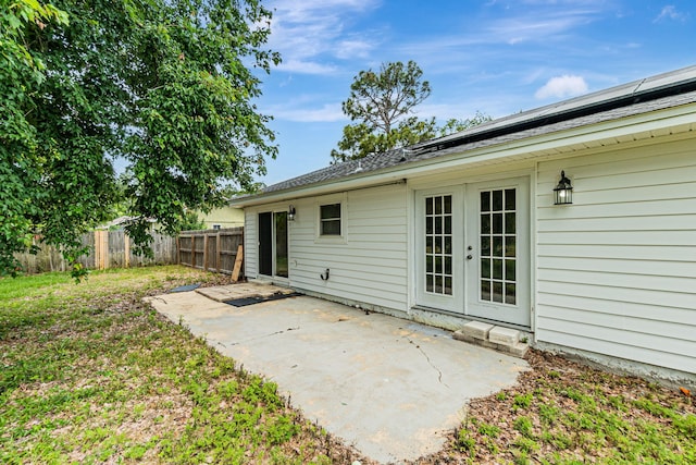 rear view of house with fence, a patio area, and french doors