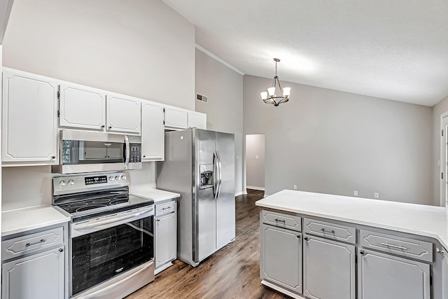 kitchen featuring stainless steel appliances, wood finished floors, a chandelier, gray cabinets, and white cabinets