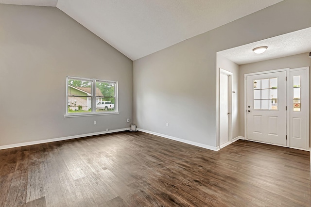 foyer entrance featuring dark wood-style floors, baseboards, and high vaulted ceiling