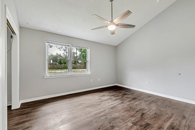 unfurnished bedroom featuring dark wood-style flooring, baseboards, vaulted ceiling, ceiling fan, and a closet
