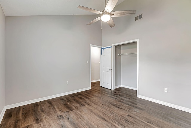unfurnished bedroom featuring baseboards, dark wood-type flooring, a closet, a high ceiling, and ceiling fan