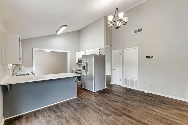 kitchen featuring appliances with stainless steel finishes, a sink, a peninsula, dark wood-style floors, and white cabinetry