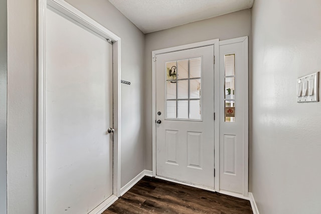 entryway with dark wood-style flooring and baseboards