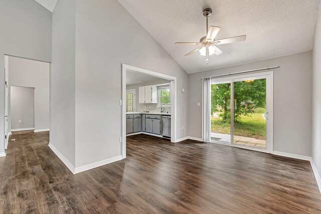 unfurnished living room with a ceiling fan, dark wood finished floors, baseboards, high vaulted ceiling, and a textured ceiling