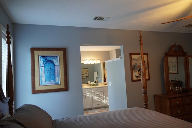 bedroom with a textured ceiling and ensuite bathroom