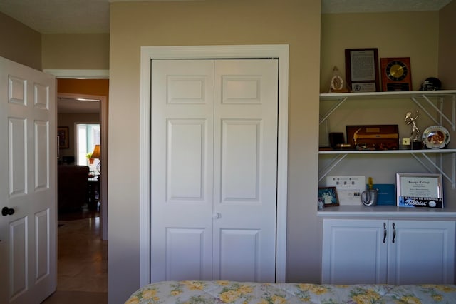 bedroom with a closet, a textured ceiling, and tile patterned floors