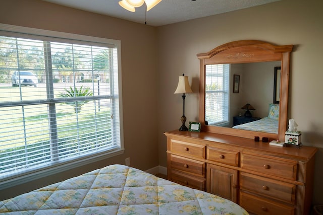 bedroom with ceiling fan and multiple windows