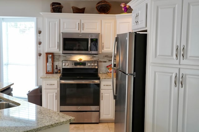 kitchen with backsplash, white cabinetry, light stone counters, and appliances with stainless steel finishes