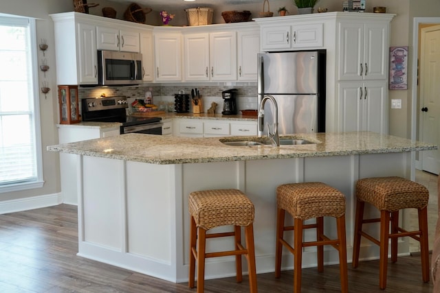 kitchen with white cabinetry, appliances with stainless steel finishes, sink, and backsplash