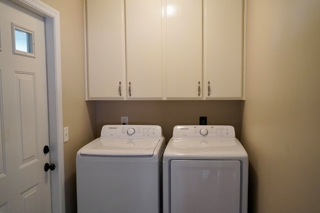 laundry area with cabinets and washer and clothes dryer