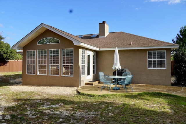 rear view of house featuring a lawn and a patio