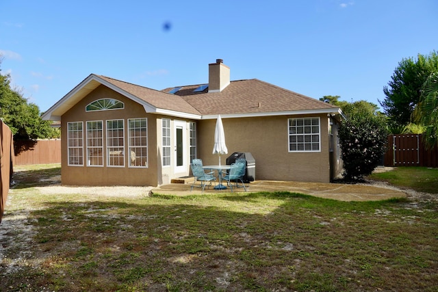 rear view of property featuring a patio and a yard