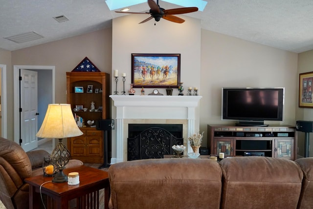 living room featuring ceiling fan, a textured ceiling, and vaulted ceiling