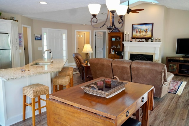 dining room with dark wood-type flooring, sink, and lofted ceiling