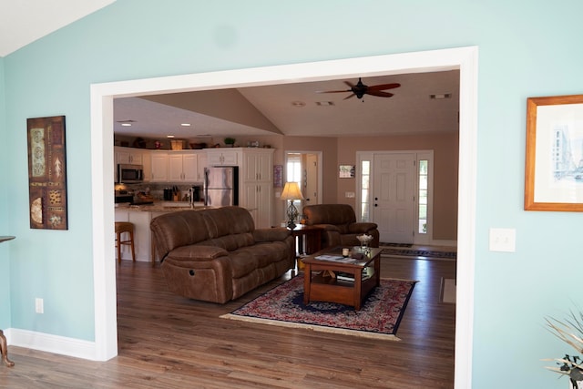 living room with dark hardwood / wood-style flooring, lofted ceiling, sink, and ceiling fan