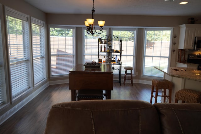 dining area with an inviting chandelier and dark hardwood / wood-style flooring