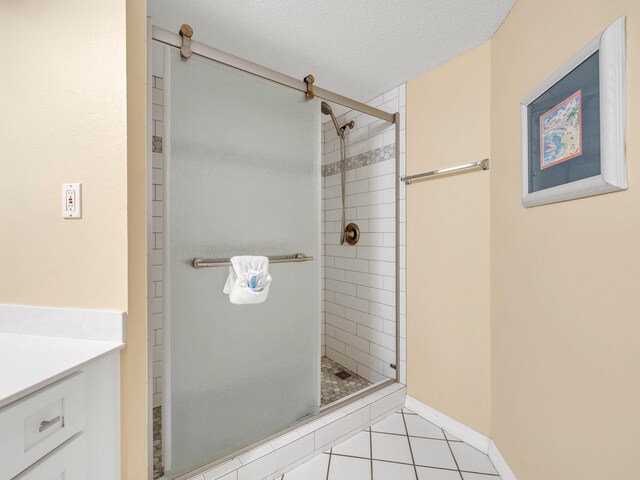 bathroom featuring tile patterned floors, vanity, a shower with shower door, and a textured ceiling