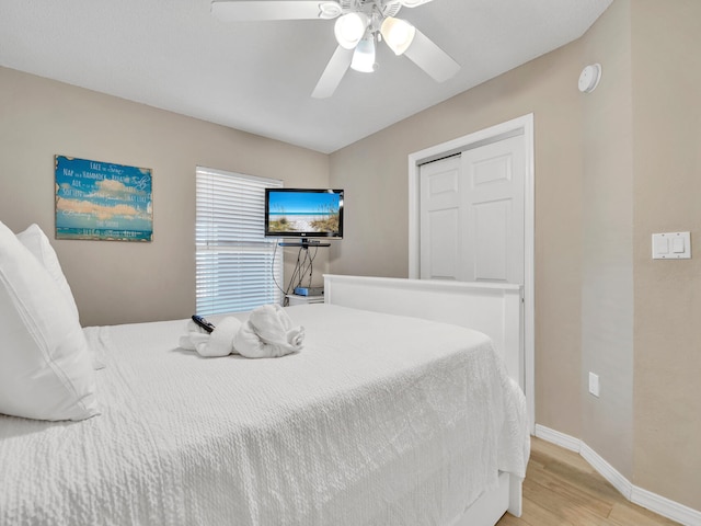 bedroom with a closet, ceiling fan, and light hardwood / wood-style flooring