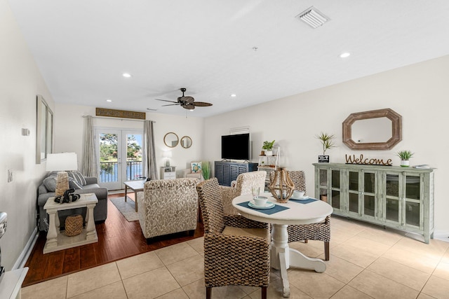 living room with light hardwood / wood-style floors, ceiling fan, and french doors