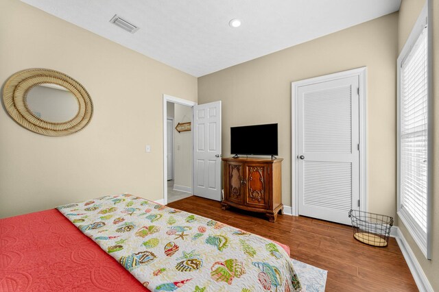 bedroom featuring wood-type flooring and multiple windows