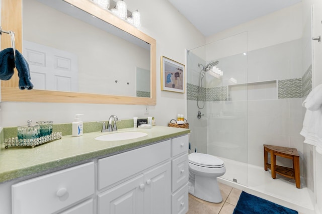 bathroom featuring vanity, tile patterned floors, toilet, and tiled shower