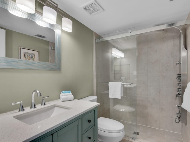 bathroom featuring vanity, toilet, and a shower with door