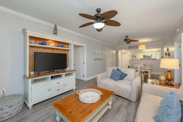 living room with crown molding, ceiling fan, and light hardwood / wood-style floors