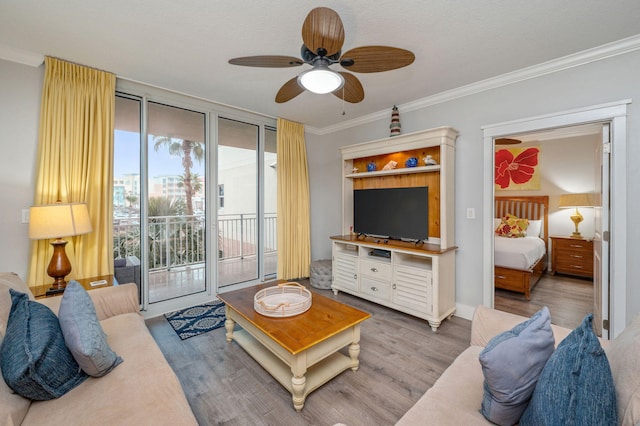 living room featuring ceiling fan, light hardwood / wood-style floors, ornamental molding, and a textured ceiling