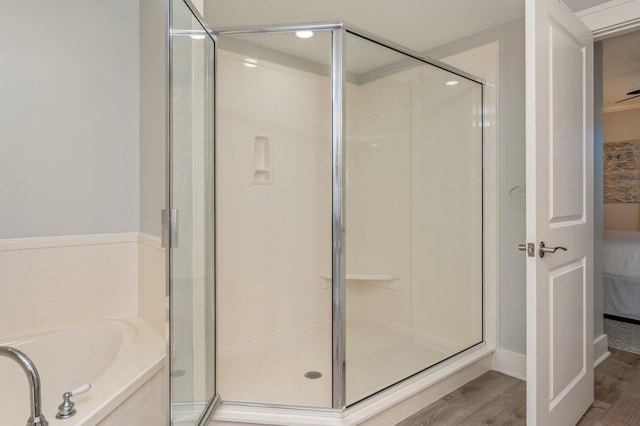 bathroom featuring hardwood / wood-style floors and separate shower and tub