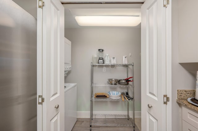 washroom with stacked washing maching and dryer