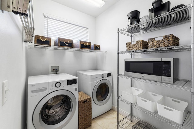 laundry area featuring washer and clothes dryer and light tile patterned floors