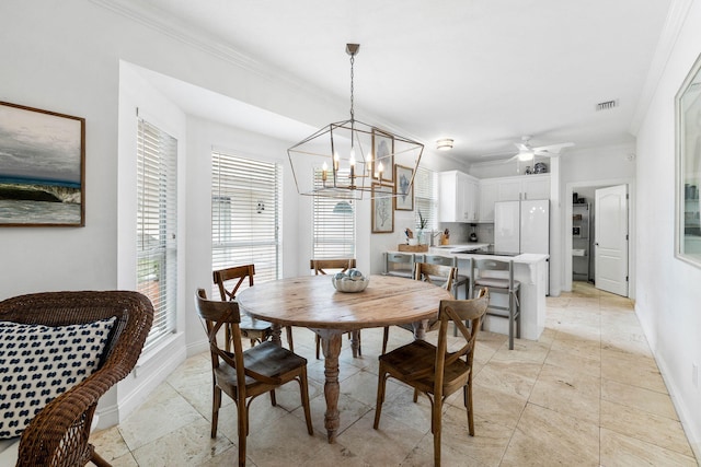 dining room featuring ceiling fan with notable chandelier, crown molding, and sink