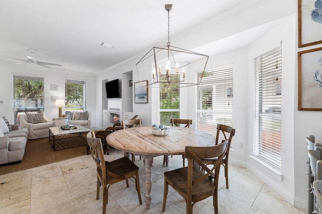 dining space featuring plenty of natural light, ceiling fan with notable chandelier, and ornamental molding