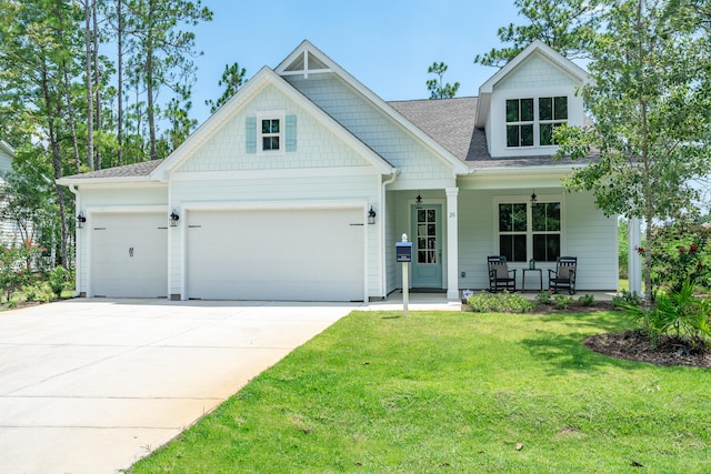 view of front of property featuring a porch, a front yard, and a garage