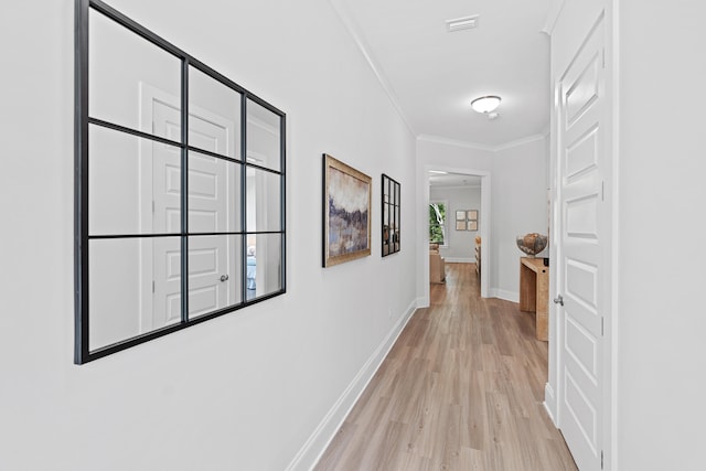 hall featuring light hardwood / wood-style floors and crown molding